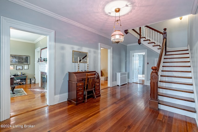 interior space with ornamental molding, a notable chandelier, and wood-type flooring