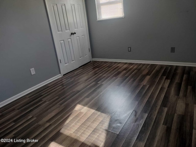 unfurnished bedroom with dark wood-type flooring