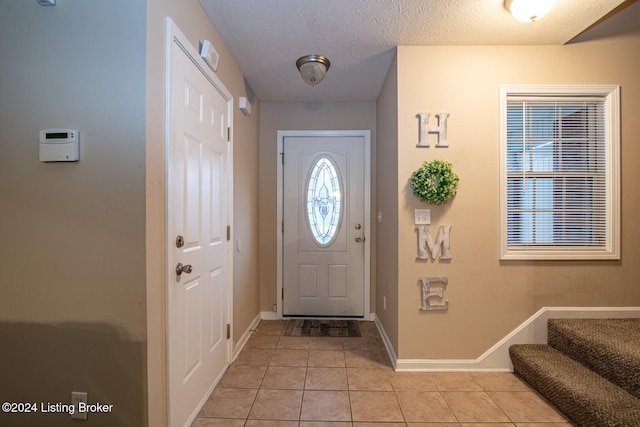 tiled foyer featuring a textured ceiling