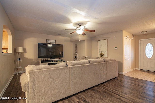 living room featuring ceiling fan, wood-type flooring, and a textured ceiling