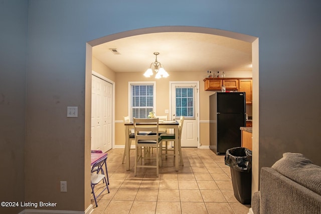 dining space with a chandelier and light tile patterned flooring