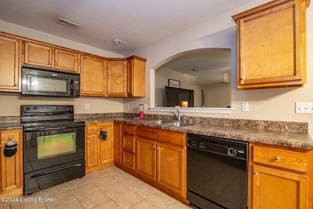 kitchen with a textured ceiling, black appliances, sink, and light tile patterned flooring