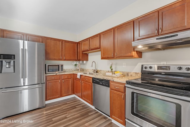 kitchen featuring sink, appliances with stainless steel finishes, light stone counters, and dark hardwood / wood-style flooring