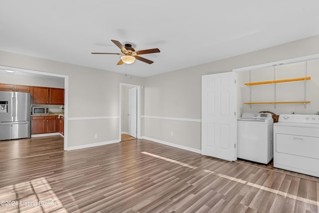 unfurnished living room with independent washer and dryer, light wood-type flooring, and ceiling fan