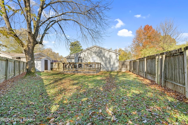 view of yard featuring a wooden deck and a shed