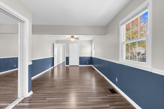 empty room with dark hardwood / wood-style floors and ceiling fan