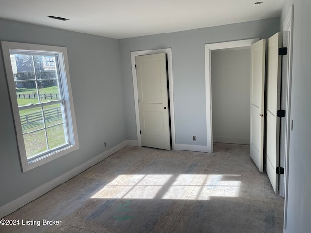 unfurnished bedroom featuring multiple windows