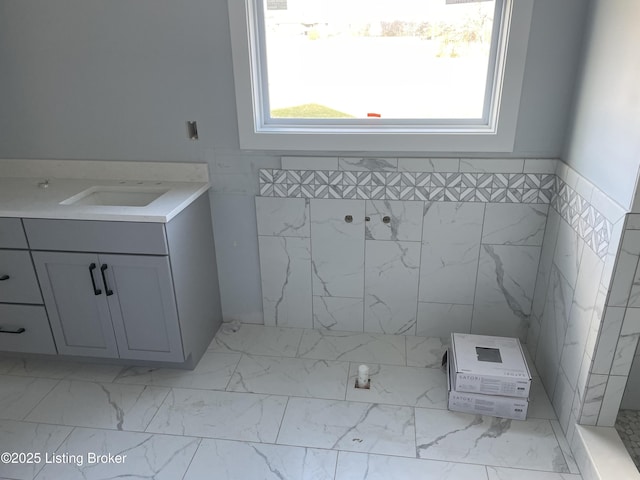 bathroom featuring vanity and tile walls