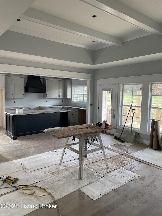 kitchen with premium range hood, beamed ceiling, light wood-type flooring, and gray cabinetry