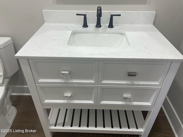 room details with vanity, wood finished floors, and toilet