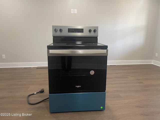 details featuring wood finished floors, stainless steel range with electric stovetop, and baseboards