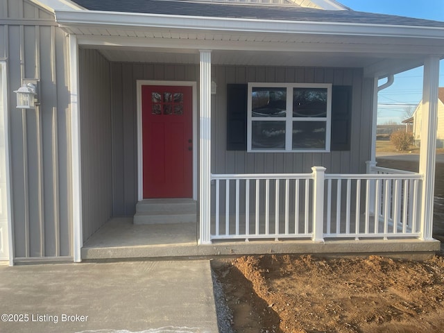 view of exterior entry featuring board and batten siding and a porch
