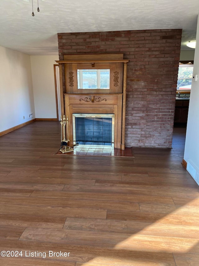 unfurnished living room with hardwood / wood-style flooring and a large fireplace