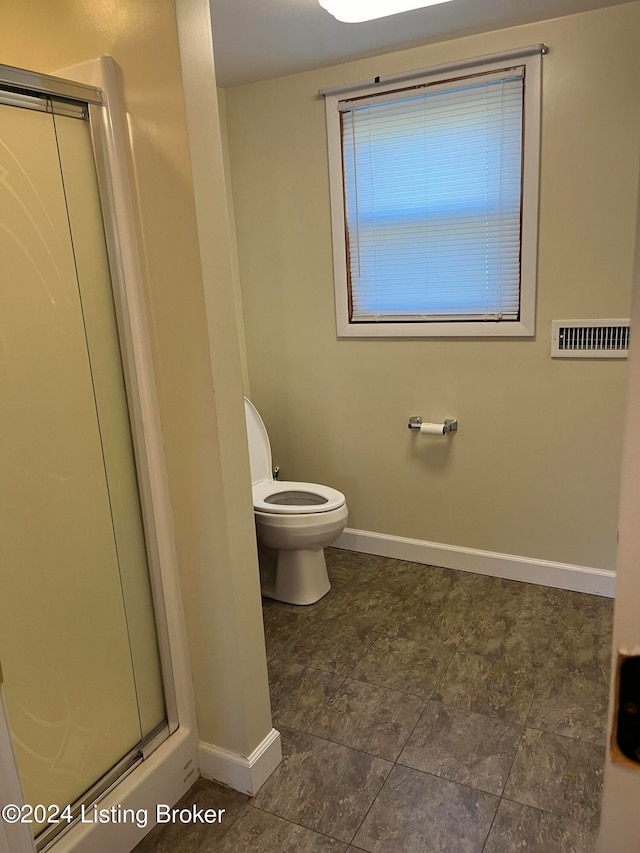 bathroom featuring an enclosed shower and toilet