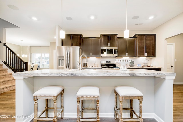 kitchen featuring pendant lighting, a kitchen bar, and stainless steel appliances