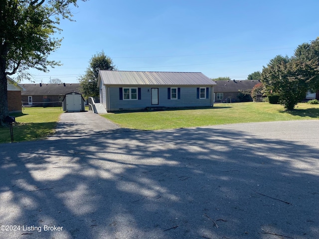 view of front of property featuring a shed and a front lawn