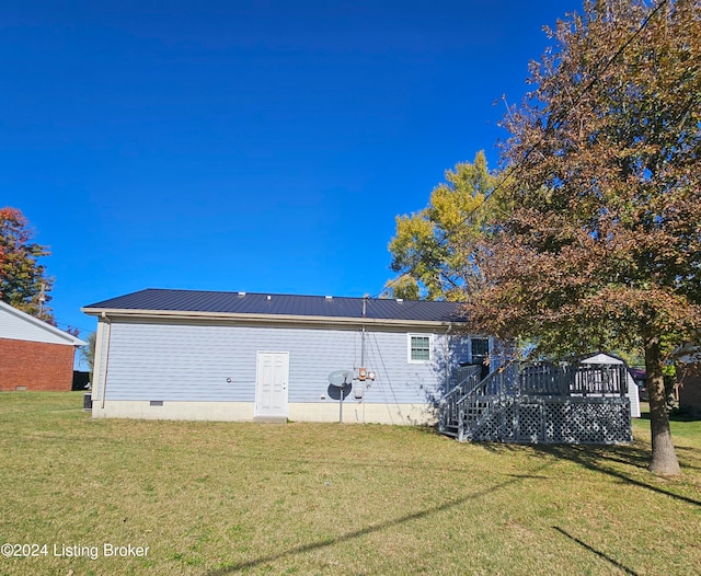 rear view of house featuring a deck and a yard
