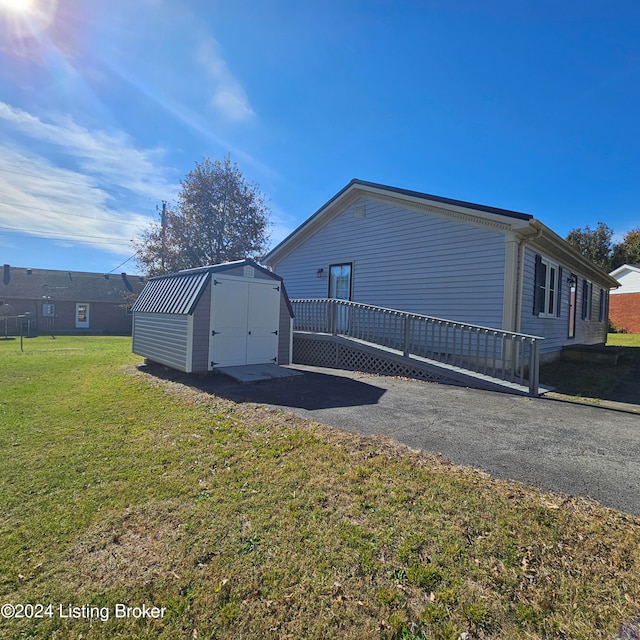 view of home's exterior with a storage shed and a lawn