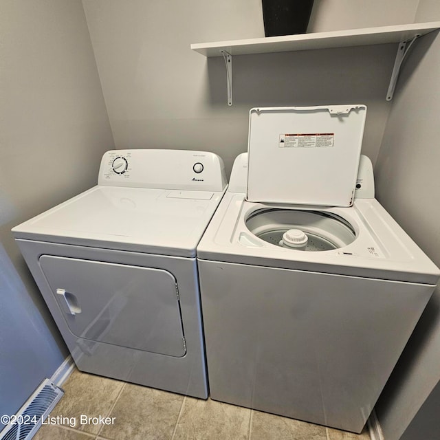 laundry area featuring light tile patterned flooring and washing machine and clothes dryer