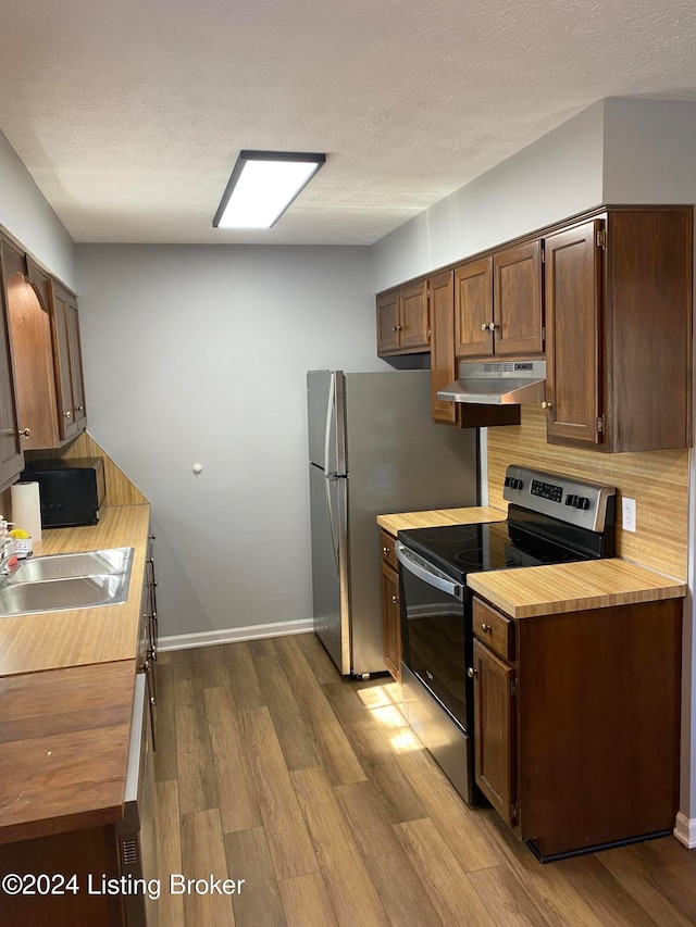 kitchen with sink, a textured ceiling, light wood-type flooring, and stainless steel electric range oven