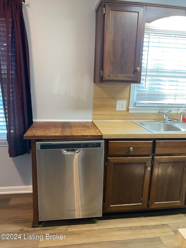kitchen featuring stainless steel dishwasher, sink, dark brown cabinets, and a healthy amount of sunlight