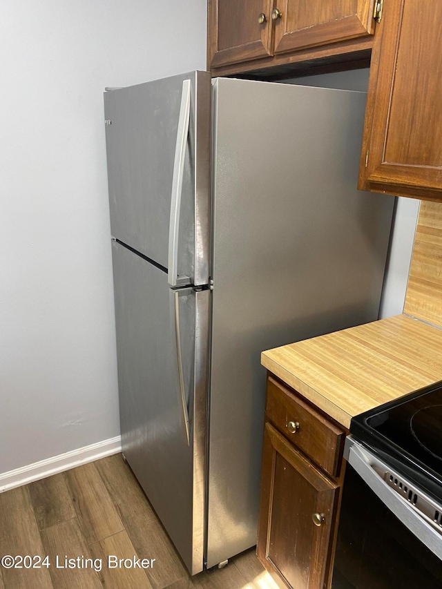 kitchen with dark hardwood / wood-style floors and stainless steel fridge