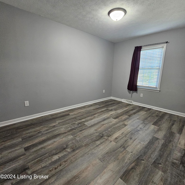unfurnished room featuring a textured ceiling and dark wood-type flooring