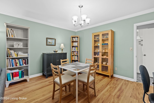 dining space with crown molding, light hardwood / wood-style flooring, and an inviting chandelier