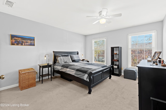 carpeted bedroom with multiple windows and ceiling fan