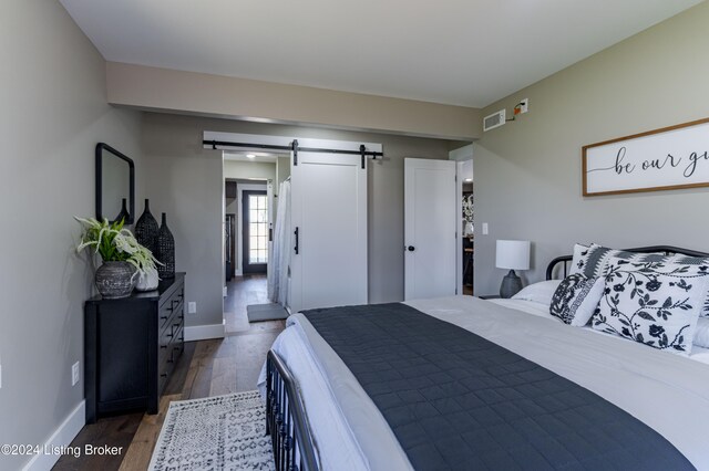 216 Millerstown St, Clarkson, KY 42726 - bedroom featuring a barn door, wood finished floors, and baseboards