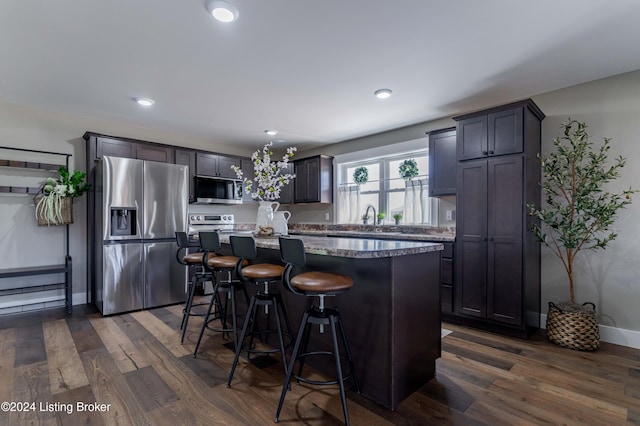 216 Millerstown St, Clarkson, KY 42726 - kitchen with appliances with stainless steel finishes, a center island, a breakfast bar, dark wood finished floors, and recessed lighting