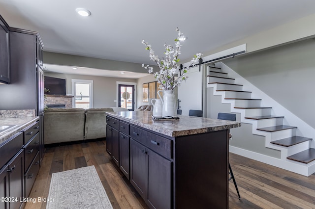 216 Millerstown St, Clarkson, KY 42726 - kitchen with a breakfast bar, dark wood finished floors, open floor plan, a kitchen island, and a fireplace