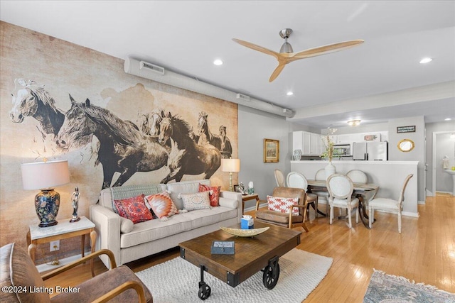 living room with light hardwood / wood-style flooring and ceiling fan