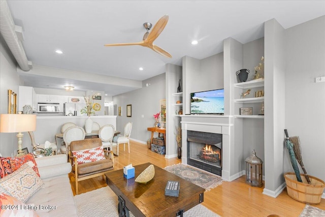 living room featuring ceiling fan and light hardwood / wood-style flooring