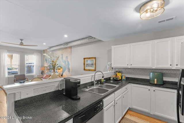 kitchen with white cabinets, dishwasher, sink, and kitchen peninsula