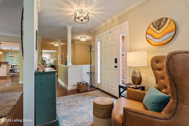 entryway with dark wood-type flooring, ornate columns, an inviting chandelier, and crown molding