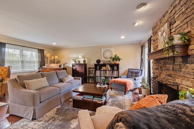 living room with dark hardwood / wood-style floors, a stone fireplace, and ornamental molding