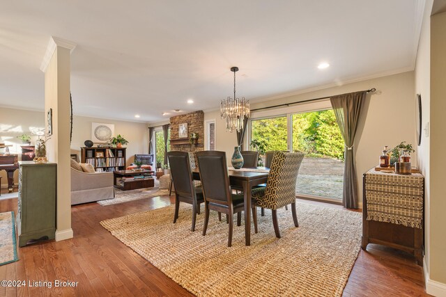 dining space featuring ornamental molding, wood-type flooring, and a chandelier