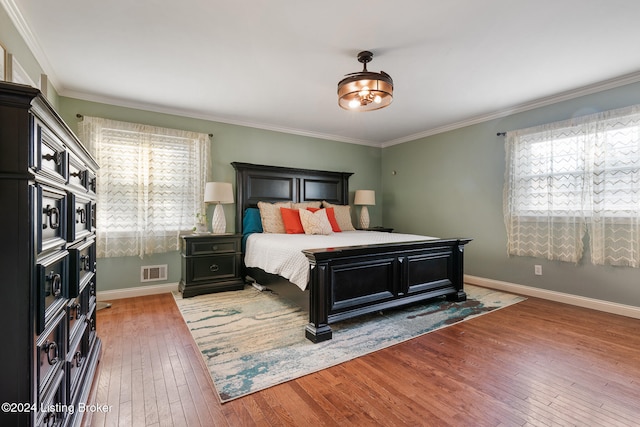 bedroom with hardwood / wood-style flooring and crown molding