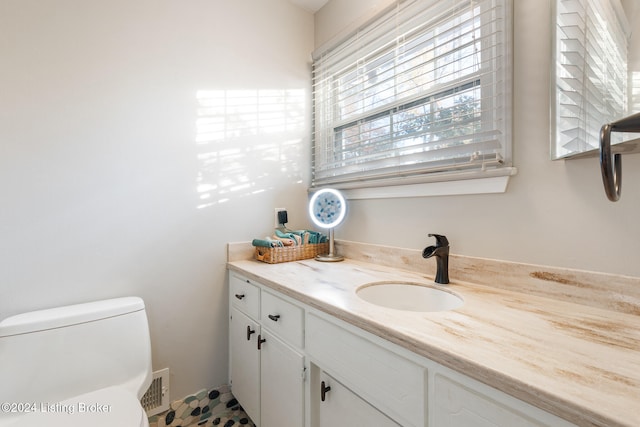 bathroom featuring vanity, tile patterned floors, and toilet