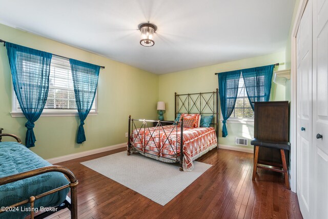 bedroom with dark wood-type flooring and a closet