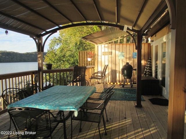 deck with grilling area and a water view