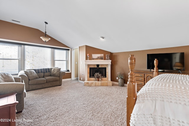 carpeted bedroom featuring lofted ceiling and a tile fireplace