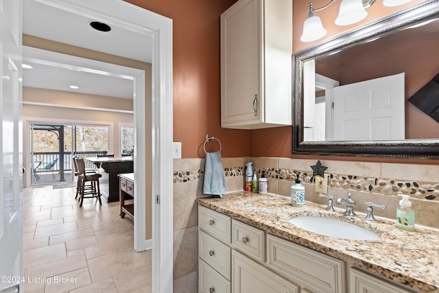 bathroom with tile walls, vanity, and tile patterned floors