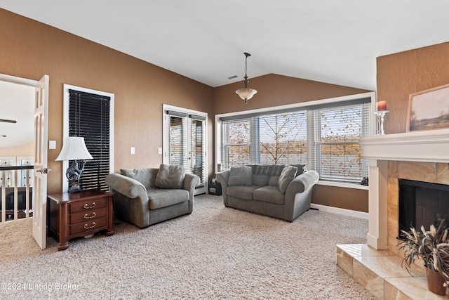 living room with light colored carpet, a tiled fireplace, and lofted ceiling