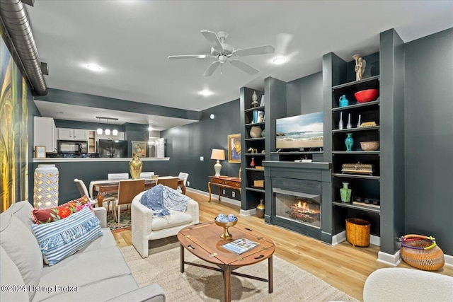 living room with light wood-type flooring and ceiling fan