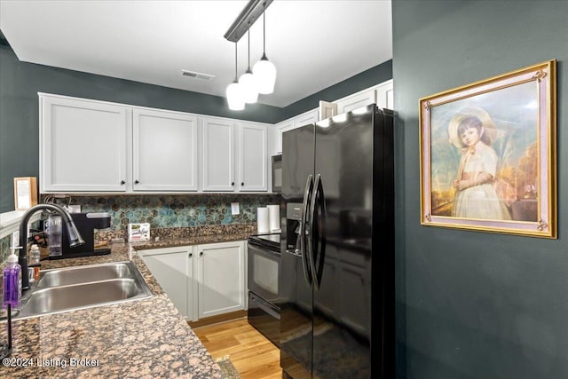 kitchen with white cabinetry, sink, black appliances, and tasteful backsplash