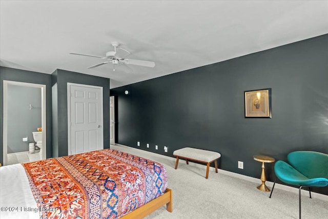 bedroom with ensuite bathroom, ceiling fan, and carpet flooring