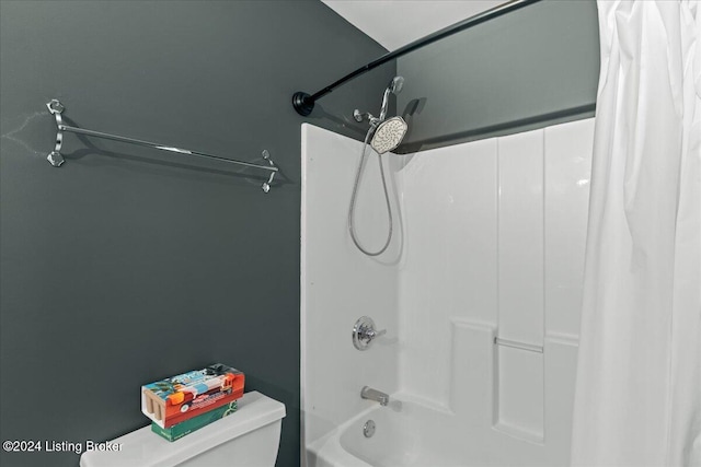 bathroom featuring toilet and shower / tub combo with curtain