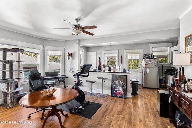 exercise area with ceiling fan and light hardwood / wood-style flooring